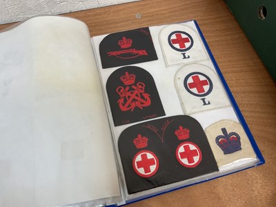 Lot 759 - Two albums of cloth Royal Navy badges and insignia to include cap tallies (2 albums)
