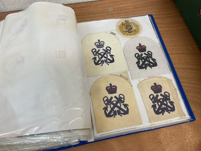 Lot 759 - Two albums of cloth Royal Navy badges and insignia to include cap tallies (2 albums)