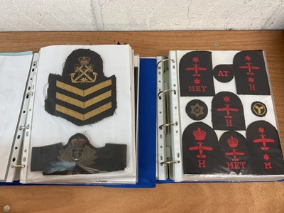 Lot 759 - Two albums of cloth Royal Navy badges and insignia to include cap tallies (2 albums)