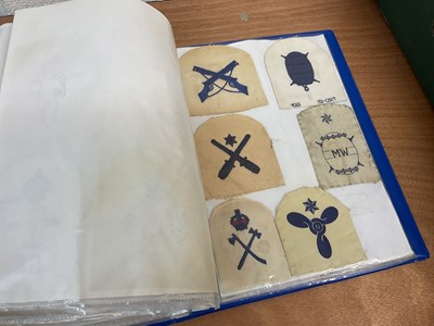 Lot 759 - Two albums of cloth Royal Navy badges and insignia to include cap tallies (2 albums)