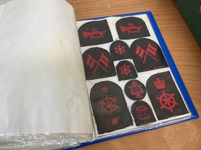 Lot 759 - Two albums of cloth Royal Navy badges and insignia to include cap tallies (2 albums)