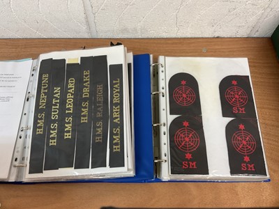 Lot 759 - Two albums of cloth Royal Navy badges and insignia to include cap tallies (2 albums)