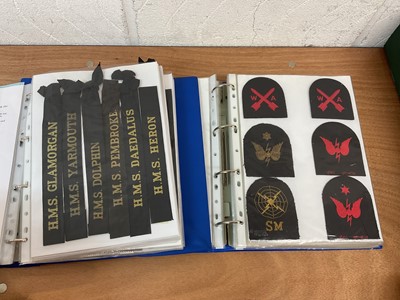 Lot 759 - Two albums of cloth Royal Navy badges and insignia to include cap tallies (2 albums)
