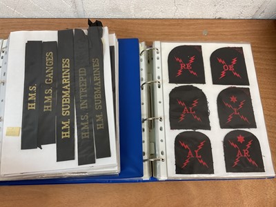 Lot 759 - Two albums of cloth Royal Navy badges and insignia to include cap tallies (2 albums)