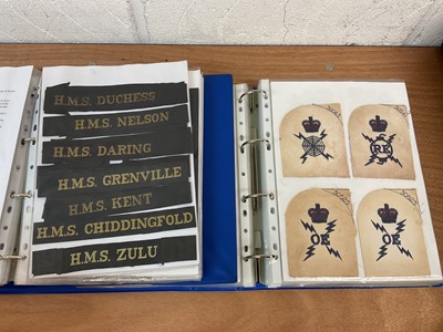 Lot 759 - Two albums of cloth Royal Navy badges and insignia to include cap tallies (2 albums)