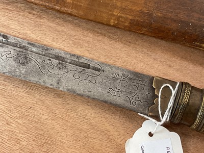 Lot 906 - 19th century Malaysian sword with brass and wooden grip, script decoration to blade in wooden sheath