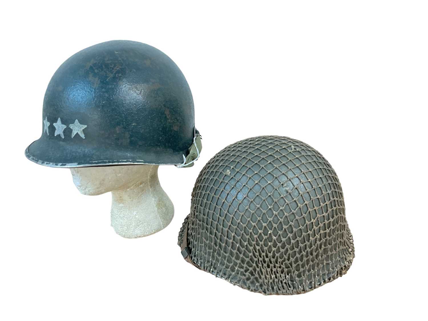 Lot 782 - American M1 steel helmet complete with liner, chinstrap and camouflage cover, together with another America M1 steel helmet with painted 4 star general insignia to front (2).