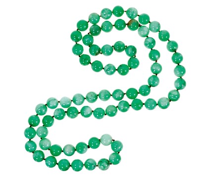 Lot 504 - Chinese jade/green hardstone bead necklace with a long string of 15.5-16mm beads, approximately 120cm in length.