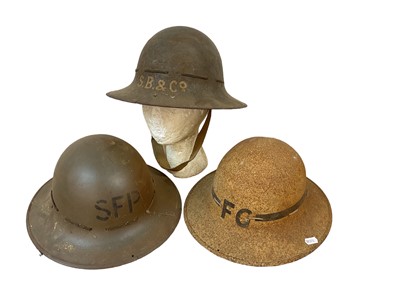 Lot 818 - Three Second World War British Zuckerman steel helmets, with painted lettering 'F.G', 'SFP' and S.B. & Co' (3)