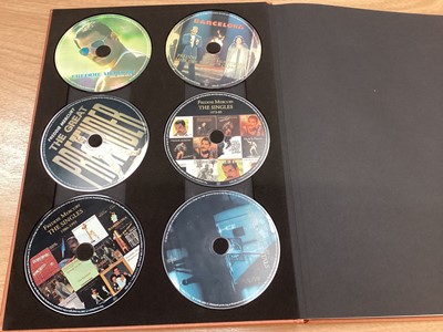 Lot 2217 - Box of Queen related items including 7 inch singles (Queen DJ 95 - purple vinyl limited edition, etc), 12 inch singles and books (40 Years of Queen and The Neal Preston Photographs, etc), together...