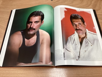 Lot 2217 - Box of Queen related items including 7 inch singles (Queen DJ 95 - purple vinyl limited edition, etc), 12 inch singles and books (40 Years of Queen and The Neal Preston Photographs, etc), together...