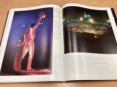 Lot 2217 - Box of Queen related items including 7 inch singles (Queen DJ 95 - purple vinyl limited edition, etc), 12 inch singles and books (40 Years of Queen and The Neal Preston Photographs, etc), together...