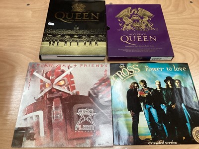Lot 2217 - Box of Queen related items including 7 inch singles (Queen DJ 95 - purple vinyl limited edition, etc), 12 inch singles and books (40 Years of Queen and The Neal Preston Photographs, etc), together...
