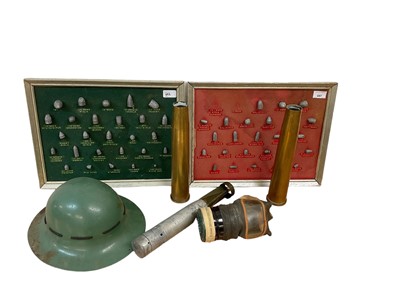 Lot 697 - Two display boards, mounted with a selection of bullets, together with a Second World War Zuckerman helmet, two brass shell cases, gas mask and incendiary bomb case.