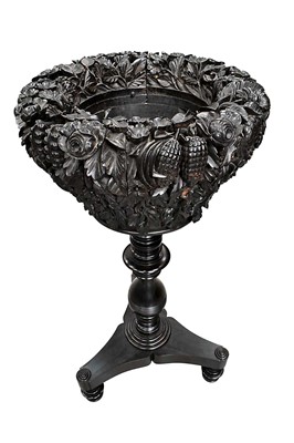 Lot 1224 - Interesting 19th century Anglo Indian carved coromandel and ebony planter, the deeply carved tapered planter supported on a turned column and trefoil base with turned feet, 86cm high