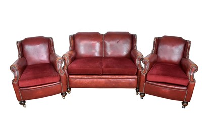 Lot 1052 - 1920s stud closed red leather upholstery three piece suite, each of wing form, raised on bun feet and castors