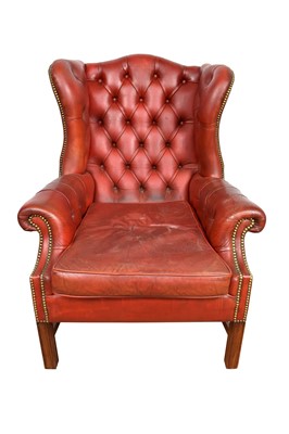 Lot 1063 - Georgian style red button leather upholstered wing armchair, on square supports