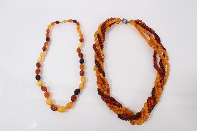 Lot 500 - Amber single strand necklace with oval polished beads, 46.5cm long, together with a five strand rope twist amber bead necklace with a silver clasp, 49cm long