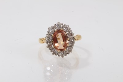 Lot 427 - Imperial topaz and diamond cluster ring with an oval cut imperial topaz surrounded ten brilliant cut diamonds in 18ct gold setting