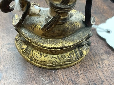 Lot 687 - Early miniature Tibetan gilt bronze deity figure, together with a Chinese gilt bronze deity figure on lotus base