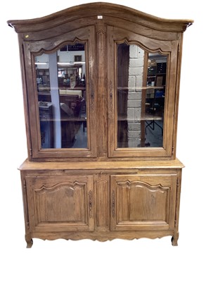 Lot 1182 - French chestnut two-height cabinet, the arched glazed top enclosing shelves, above twin panelled cupboard doors below, on shaped bracket feet