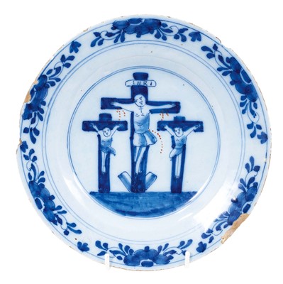 Lot 143 - An 18th century blue and white delft ware plate depicting the crucifixion of Christ, 23cm diameter