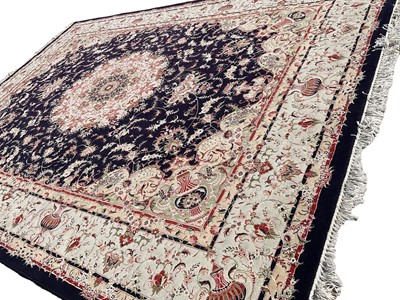Lot 1256 - Good quality Tabriz style rug, retailed by the Mashad Carpet Co, with central foliate medallion on navy ground on scrolling main border, tassel ends, approximately 403 x 300cm