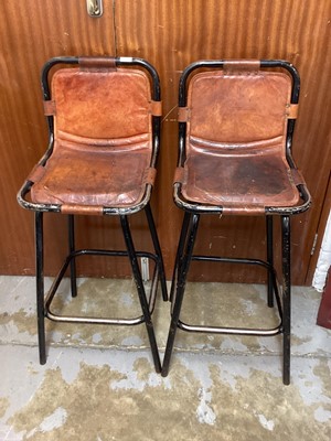 Lot 1399 - A pair of brown leather and painted tubular metal bar stools in the style of Charlotte Perriand