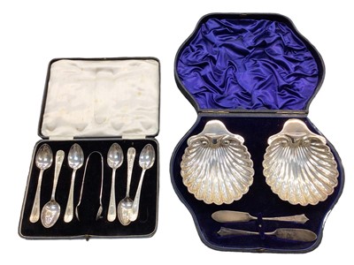 Lot 1023 - Pair of silver shell shaped butter dishes and butter knives in fitted case and a set of six silver teaspoons and pair silver sugar tongs in fitted case