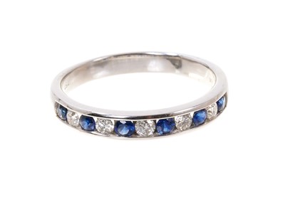 Lot 789 - Diamond and sapphire eternity ring with a half hoop of five round brilliant cut diamonds and six round mixed cut blue sapphires in 18ct white gold channel setting. Estimated total diamond weight ap...