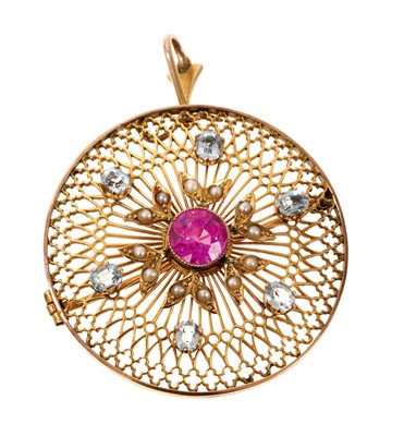 Lot 778 - Early 20th century Belle Époque pendant with a pink stone to the centre, seed pearls and pale blue stones, on a pierced openwork circular plaque