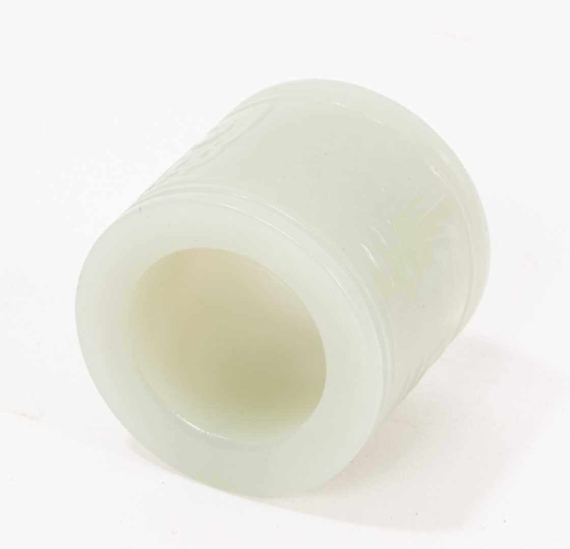 Lot 1046 - Chinese celadon jade archer's ring, relief carved with character marks