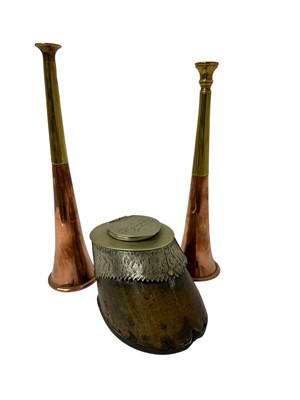 Lot 80 - Two copper and brass hunting horns, 21.5cm and 23cm, together with a horse hoof inkwell with silver plated mounts, engraved 'Flying Fox' (3)