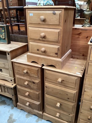 Lot 1218 - Pair of pine narrow chests of four drawers, 45.5cm wide, 40cm deep, 86cm high, together with a matching three drawer bedside chest (3)