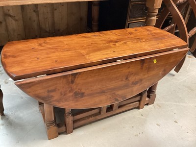 Lot 1242 - Hardwood oval drop leaf table on turned and block legs joined by stretchers