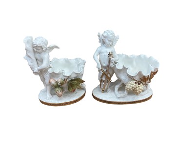 Lot 336 - Two similar late 19th century Moore Bros. porcelain sweetmeat baskets decorated with cherubs and gilt ornament, Greek Key pattern to footrims, stamped and impressed marks, 16.5cm high