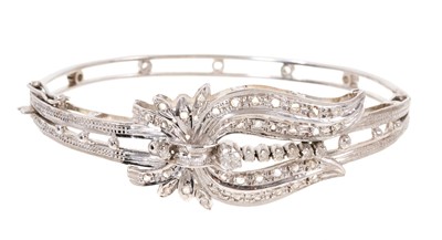 Lot 699 - White gold and diamond hinged bangle with rose cut and single cut diamonds in illusion setting