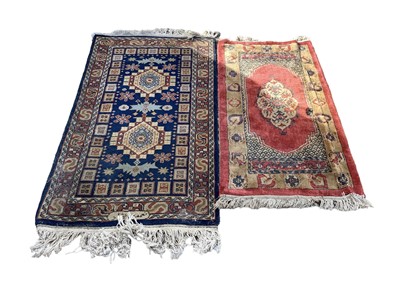 Lot 1324 - Eastern rug with two central medallions on blue and red ground, 139cm x 75cm together with another rug, 120cm x 60cm (2)