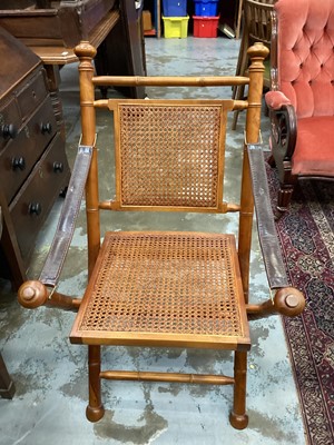 Lot 1329 - Folding chair with cane seat and back, and leather arm supports