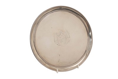 Lot 535 - George III silver card tray of circular form, with engraved armorial shield and bead border, on three bead edged feet (London 1786) Thomas Chawner. All at approximately 12ozs. 20.7cm diameter