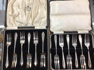 Lot 1100 - Two set of six silver cake forks in fitted cases