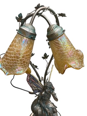 Lot 267 - Tiffany style table lamp with two iridescent glass shades and stained glass wings to the bronzed resin fairy.