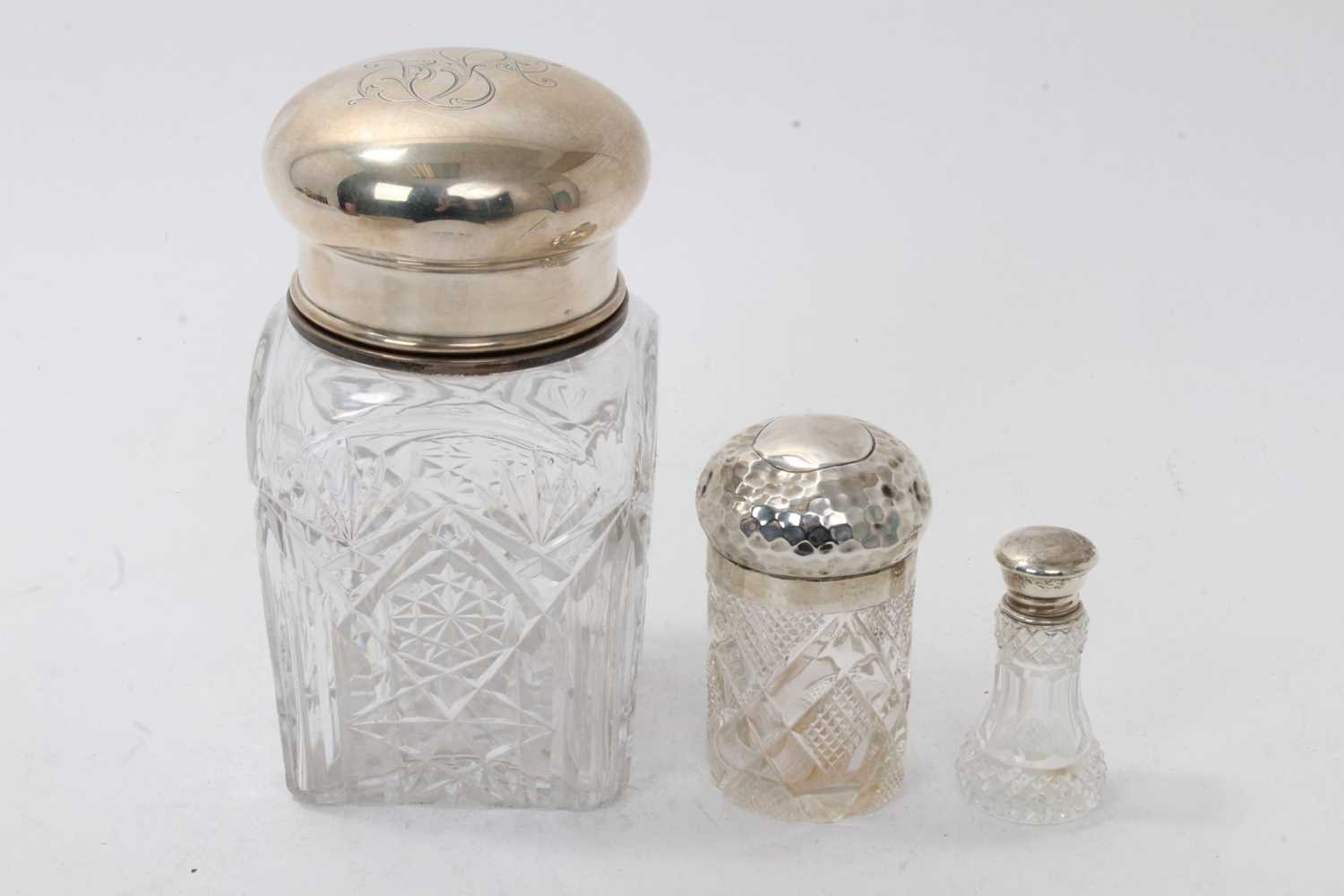 Lot 1102 - Large cut glass jar, with white metal cover and inner cover, and two silver topped dressing table jars