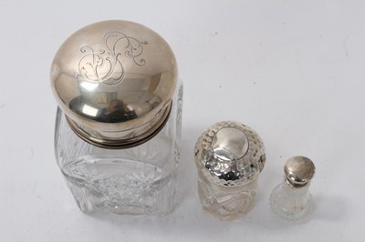 Lot 1102 - Large cut glass jar, with white metal cover and inner cover, and two silver topped dressing table jars
