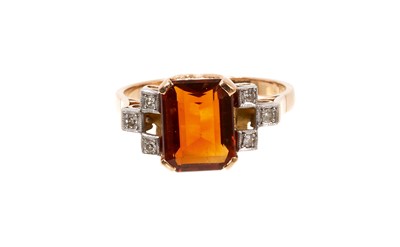 Lot 670 - Art Deco-style garnet and diamond ring with a rectangular cut-cornered step cut garnet flanked by six single cut diamonds in platinum grain setting, pierced gold scroll gallery on gold shank.