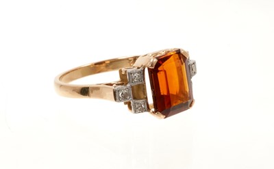 Lot 670 - Art Deco-style garnet and diamond ring with a rectangular cut-cornered step cut garnet flanked by six single cut diamonds in platinum grain setting, pierced gold scroll gallery on gold shank.