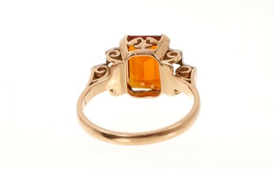 Lot 670 - Art Deco-style garnet and diamond ring with a rectangular cut-cornered step cut garnet flanked by six single cut diamonds in platinum grain setting, pierced gold scroll gallery on gold shank.