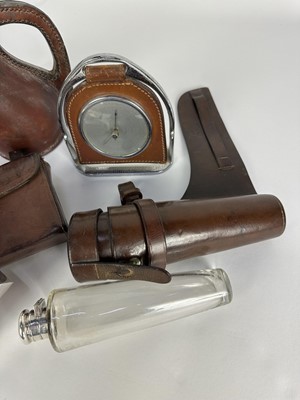 Lot 1244 - Leather cased glass saddle flask with silver plated top, James Dixon & Sons sandwich box in leather case for saddle mounting, desk barometer suspended from a stirrup and a leather covered jack (4)