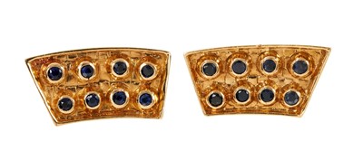 Lot 828 - Pair of Lalaounis 18ct gold and sapphire earrings, each with eight collet-set round mixed cut blue sapphires on a curved textured gold panel, with clip fitting, signed. 26mm.