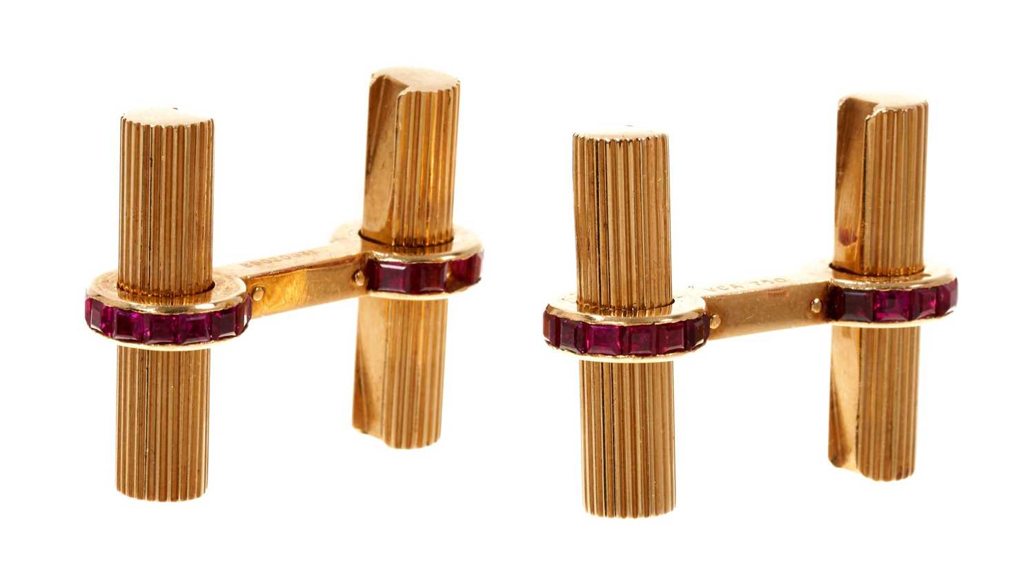 Lot 809 - Pair of Van Cleef & Arpels ruby and gold cufflinks, the ribbed gold tubular bars mounted with a ring of calibre cut rubies, all in 18ct yellow gold. Signed VCA and numbered B9020G31.